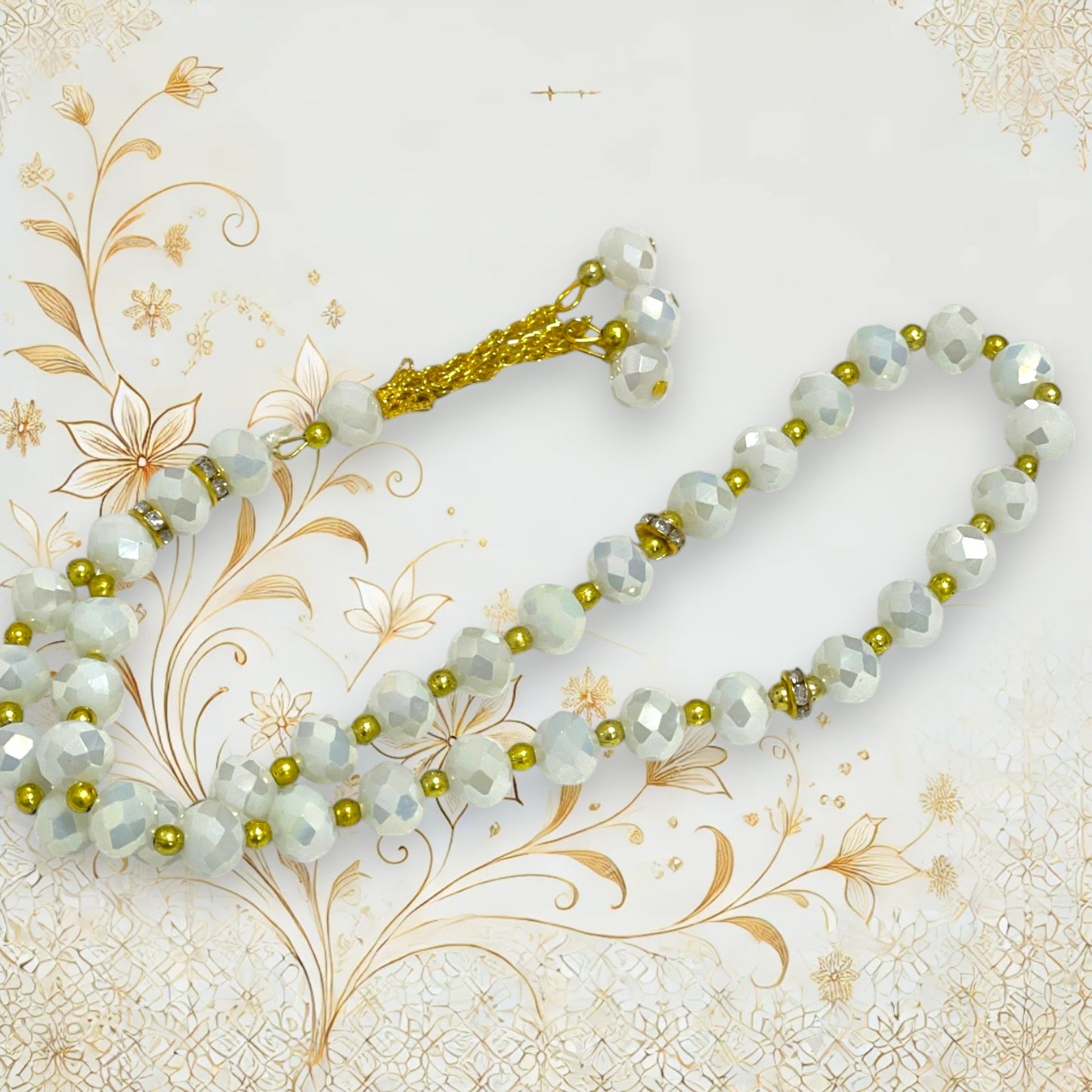 Weiße Gebetskette mit schimmernden Kristallen und goldfarbenen Elementen.
