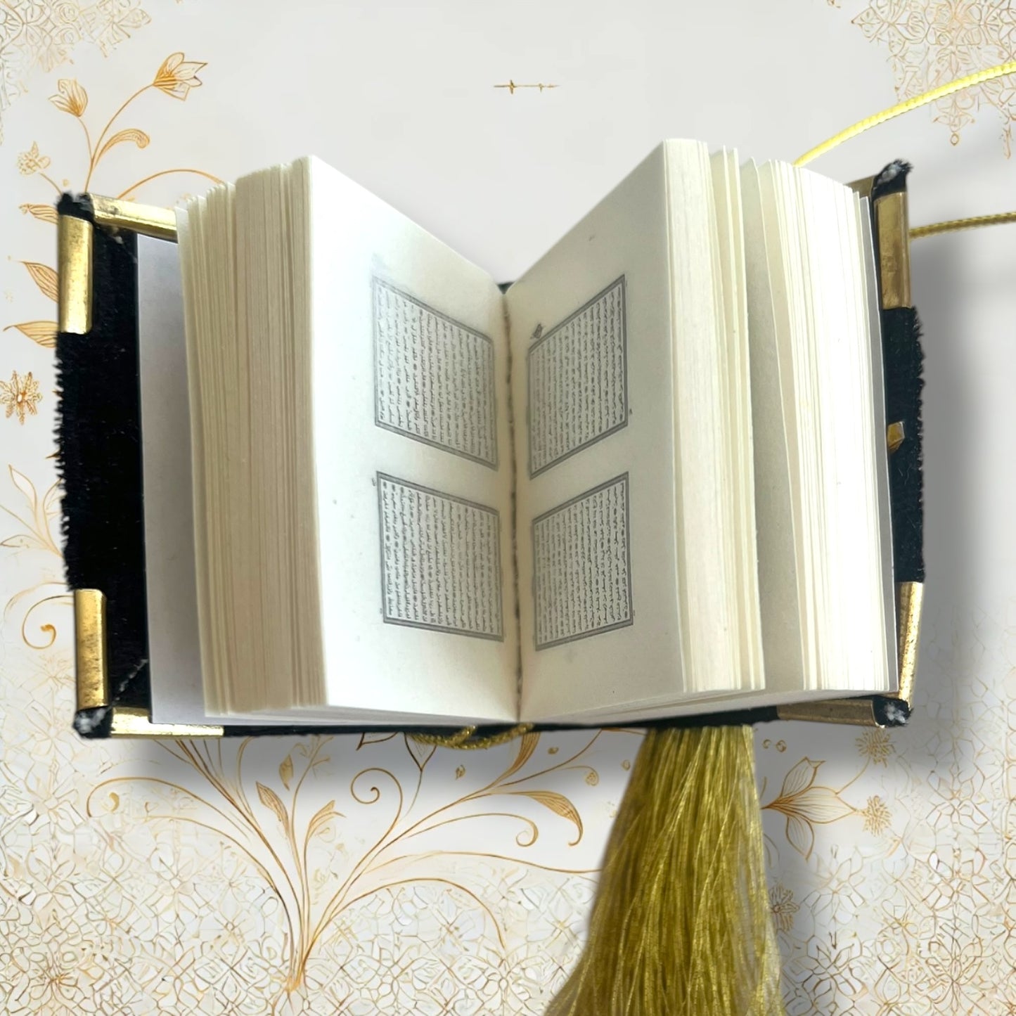  Geöffneter Auto-Quran zeigt fein bedruckte arabische Seiten im Miniaturformat