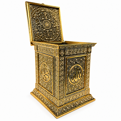 Geöffnete goldfarbene Koran-Geschenkbox mit verziertem Deckel auf weißem Hintergrund